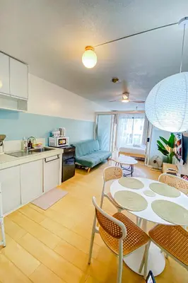 a kitchen and living room with a table and chairs at Cozy Oasis Free pool, netflix, playground in Manila