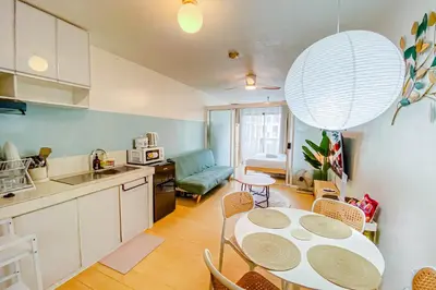 a kitchen and living room with a table and chairs at Cozy Oasis Free pool, netflix, playground in Manila