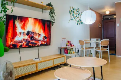 a room with two tables and a tv on the wall at Cozy Oasis Free pool, netflix, playground in Manila