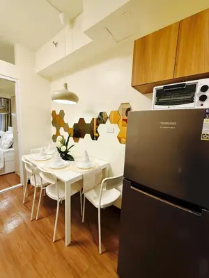a kitchen and dining room with a table and a refrigerator at The Camden Place 1BR Condo Apartment in Manila