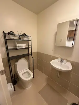 a bathroom with a toilet and a sink at The Camden Place 1BR Condo Apartment in Manila