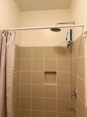 a bathroom with a shower with a shower curtain at The Camden Place 1BR Condo Apartment in Manila