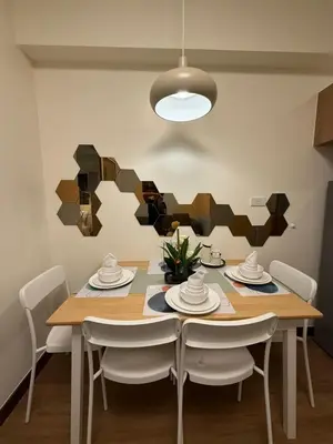 a dining room with a wooden table and chairs at The Camden Place 1BR Condo Apartment in Manila