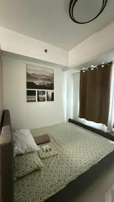 a bedroom with a large bed with a window at SeaResidence TowerA,Netflex,Wifi near MOA in Manila