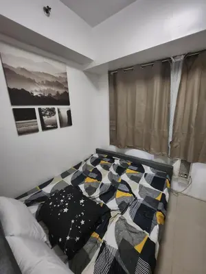 a bedroom with a bed with a quilt on it at SeaResidence TowerA,Netflex,Wifi near MOA in Manila
