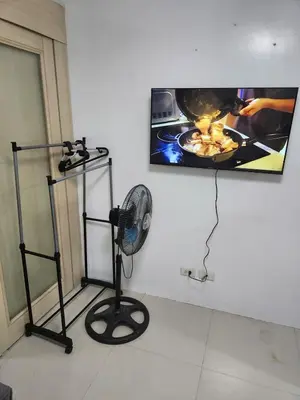 a room with a fan and a tv on the wall at SeaResidence TowerA,Netflex,Wifi near MOA in Manila
