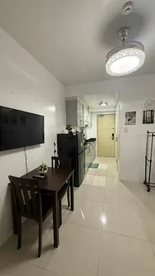 a living room with a table and a kitchen at SeaResidence TowerA,Netflex,Wifi near MOA in Manila