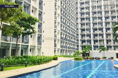a swimming pool in front of a large building at City View Staycation Near Mall of Asia and Airport in Manila
