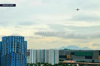 a plane flying over a city with tall buildings at City View Staycation Near Mall of Asia and Airport in Manila