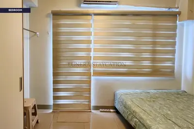 a bedroom with wooden blinds on a sliding door at City View Staycation Near Mall of Asia and Airport in Manila