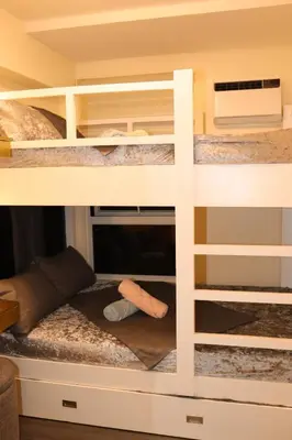 a bunk bed with a desk and a computer on it at Palacio Inglaterra in Manila