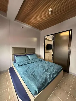 a bedroom with a large bed with blue sheets at Stay at FB Harrison near World Trade Center MOA and NAIA in Manila