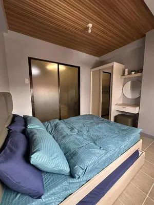 a bedroom with a large bed with blue sheets at Stay at FB Harrison near World Trade Center MOA and NAIA in Manila
