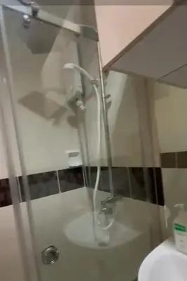 a bathroom with a glass shower with a sink at Stay at FB Harrison near World Trade Center MOA and NAIA in Manila