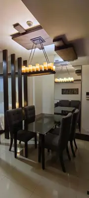 a dining room with a black table and chairs at Greenbelt Excelsior in Manila