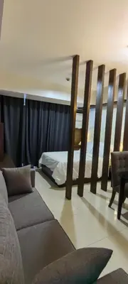 a bedroom with a bed and a couch in a room at Greenbelt Excelsior in Manila