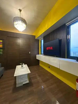 a lobby of a hotel with a table and a tv at Cozy Escape by Dave 4563 in Manila