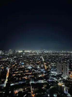 a view of a city at night at Cozy Escape by Dave 4563 in Manila