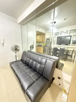 a black leather couch in a living room at Shore 1 residences Tower D Pasay City in Manila