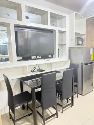 a dining room with a table and chairs and a television at Shore 1 residences Tower D Pasay City in Manila