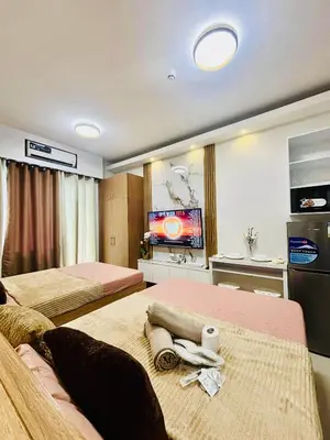 a hotel room with two beds and a flat screen tv at Shore 2 Residences Tower 1 in Manila
