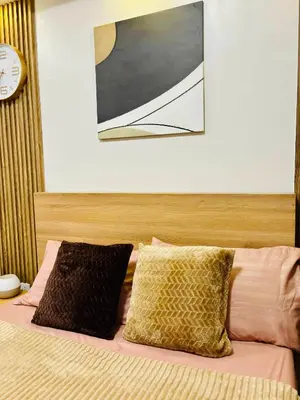 a bed with two pillows and a picture above it at Shore 2 Residences Tower 1 in Manila