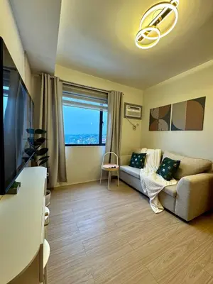 a living room with a couch and a large window at A and A Place - The Hive C - Free Parking in Taytay