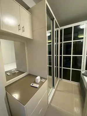 a small kitchen with white cabinets and a table at Shore 1 Residences Tower D Pasay in Manila