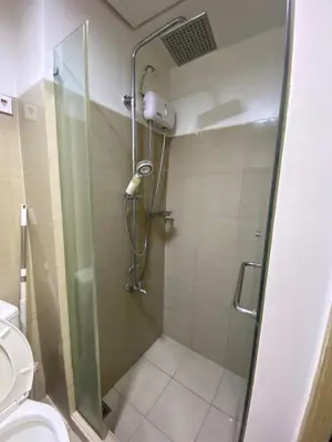 a shower in a bathroom with a toilet at Shore 1 Residences Tower D Pasay in Manila