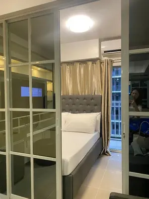 a bedroom with a bed and a glass wall at Shore 1 Residences Tower D Pasay in Manila