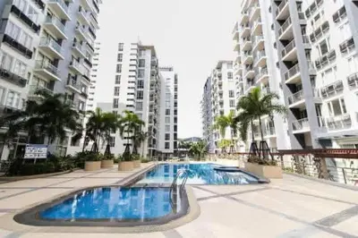 a swimming pool in front of some tall buildings at Cozy haven across terminal 3 in Manila