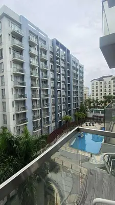 a large apartment building with a pool in front of it at Cozy haven across terminal 3 in Manila