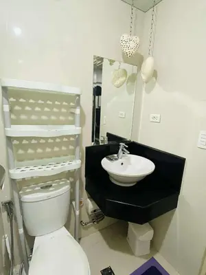 a bathroom with a toilet and a sink at Cozy Haven Across Terminal 3 in Manila