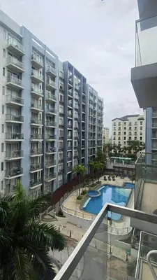 an apartment complex with a swimming pool and buildings at Cozy Haven Across Terminal 3 in Manila