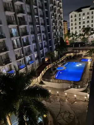 a large swimming pool in front of a building at Cozy Haven Across Terminal 3 in Manila