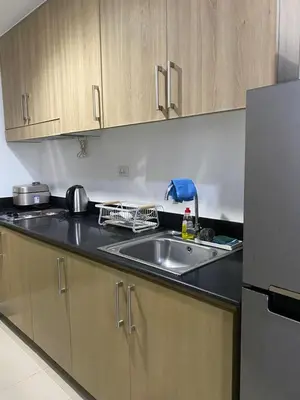 a kitchen with a sink and a refrigerator at Shore 1 Spacious Smart Home 3C in Manila