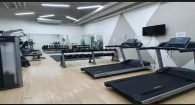 a gym with several treadmills and machines in a room at Dagos Studio City Filinvest Alabang in Manila
