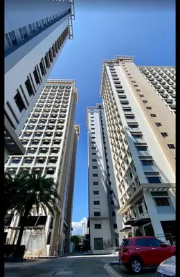 two tall white buildings with a car parked between them at Dagos Studio City Filinvest Alabang in Manila