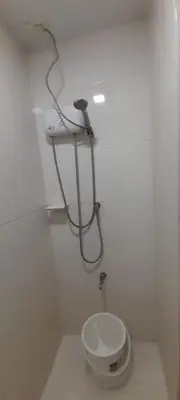 a white bathroom with a toilet and a shower at Dagos Studio City Filinvest Alabang in Manila