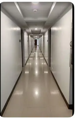 a hallway of an office building with white floors and ceilings at Dagos Studio City Filinvest Alabang in Manila
