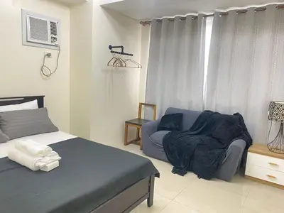 a bedroom with a bed and a chair and a window at 2BR walking distance to MOA - near PICC,NAIA,STAR CITY by JBCO Staycation Jha in Manila