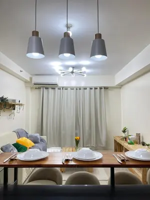 a living room with a table and a couch at 2BR walking distance to MOA - near PICC,NAIA,STAR CITY by JBCO Staycation Jha in Manila
