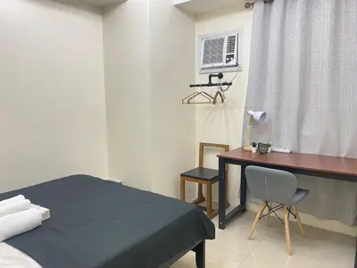 a bedroom with a bed and a desk and a window at 2BR walking distance to MOA - near PICC,NAIA,STAR CITY by JBCO Staycation Jha in Manila