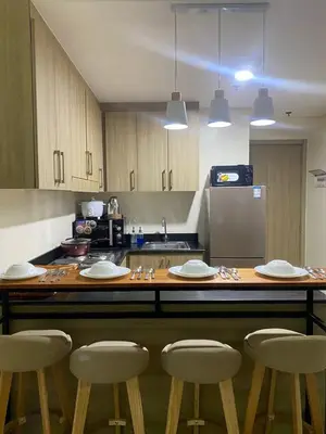 a kitchen with a table with chairs and a counter top at 2BR walking distance to MOA - near PICC,NAIA,STAR CITY by JBCO Staycation Jha in Manila