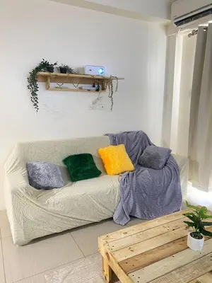 a living room with a couch with colorful pillows at 2BR walking distance to MOA - near PICC,NAIA,STAR CITY by JBCO Staycation Jha in Manila