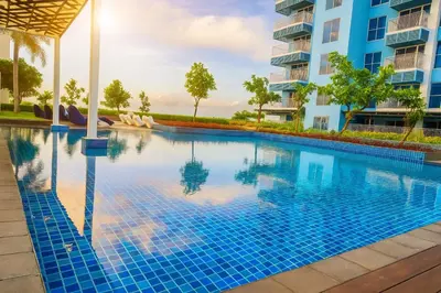 a swimming pool in a building with blue tiles at Modern 3BR 180 Degree Seaview Beside Okada Manila 14 in Manila