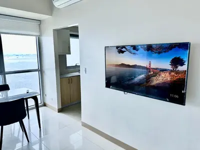 a flat screen tv hanging on a wall in a room at Modern 3BR 180 Degree Seaview Beside Okada Manila 14 in Manila
