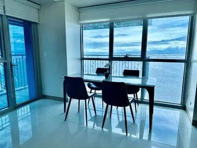 a dining room with a table and chairs and windows at Modern 3BR 180 Degree Seaview Beside Okada Manila 14 in Manila