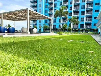 a large grassy area in front of a large building at Modern 3BR 180 Degree Seaview Beside Okada Manila 14 in Manila