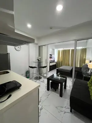 a kitchen and living room with a couch and a table at Azure Resort and Staycation by Miss Angie in Manila